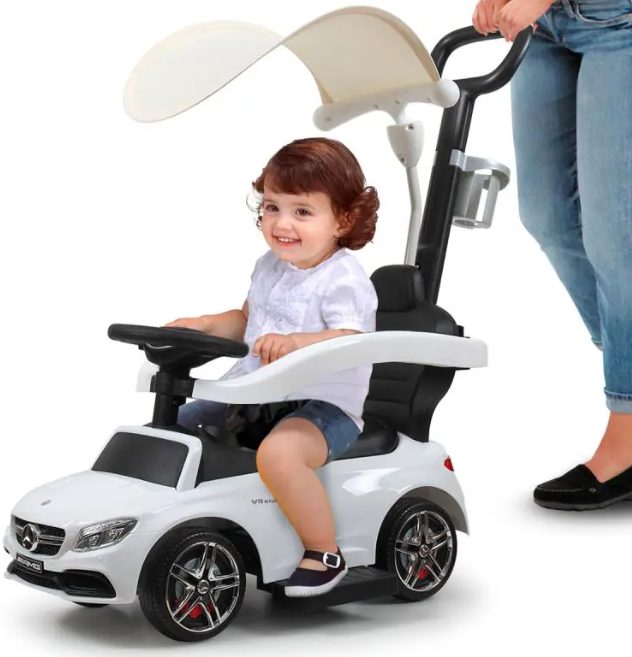 A kid is riding the toddler push car.