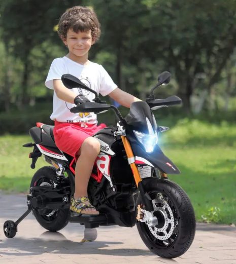 A kid is riding the kids motorcycle.