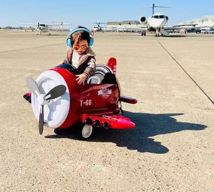 A kid is riding the airplane ride on toy.